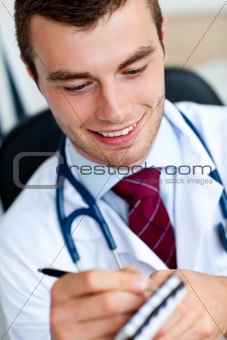 Caucasian male doctor writing a perscription 