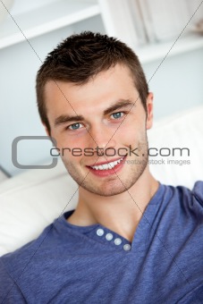 Smiling young man sitting on a sofa