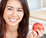 Smiling young woman holding a red an apple