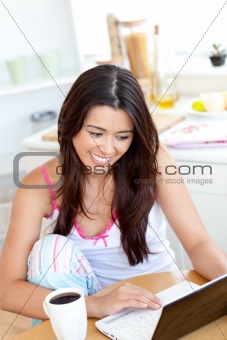 Beautiful Woman using a laptop in the kitchen 