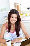Cute Woman using a laptop in the kitchen 