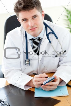 Portrait of an attractive male doctor sitting at his desk