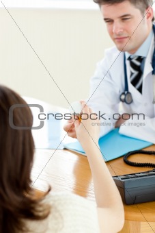 Assertive male doctor giving pills to his patient during a visit