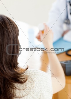 Close-up of an assertive male doctor giving pills to his patient during a visit