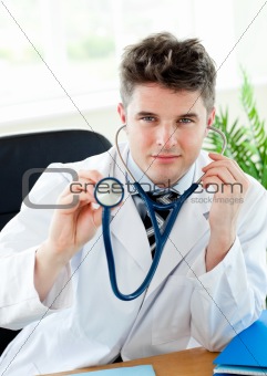 Portrait of an attractive male doctor sitting at his desk with a female patient with a stethoscope