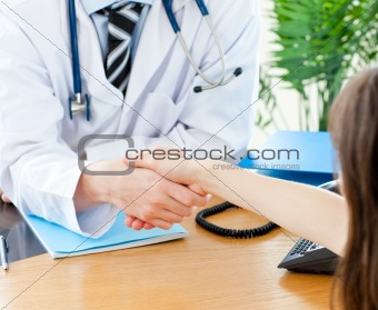 Close-up of a delighted male doctor welcome his patient in his practice