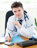 Portrait of an attractive male doctor sitting at his desk with a female patient with a pen