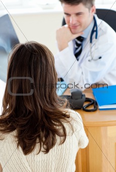 Attractive doctor showing his female patient a x-ray