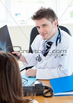 Cute doctor showing his female patient a x-ray