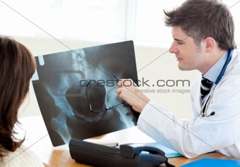 Caucasian doctor showing his female patient a x-ray