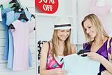 Cute young women choosing clothes together