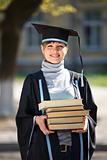 Young female graduate with a stack of books
