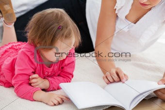 Kind mother reading a book with children
