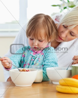 Helping mother and daughter having breakfast