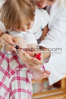 Helping mother making her daughter's nails 