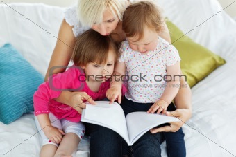 Cute mother reading a book with children