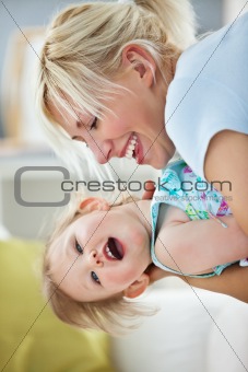 Simper mother playing with her daughter