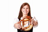 Young woman with Bavarian dirndl holding Oktoberfest pretzel
