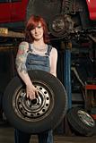 Female mechanic changing tires