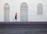 Fast paced man runs down city street.