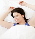 Smiling young woman lying in her bed relaxing