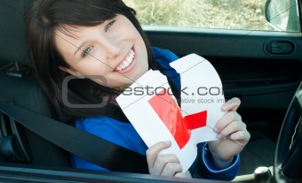 Cheerful young female driver tearing up her L sign 