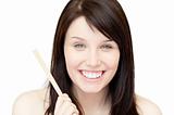 Portrait of a glowing young woman holding a nail file 