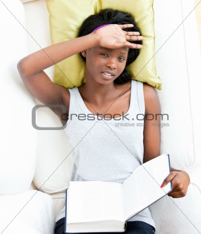 Afro-american teenager feeling sick holding a book 