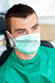 Serious male surgeon with mask and scrubs 