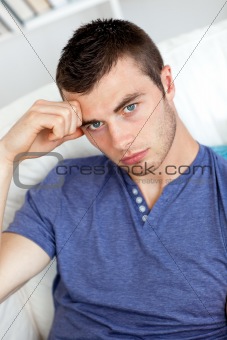 Depressed young man sitting on the sofa 
