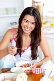 Smiling asian woman eating muesli with fruits 
