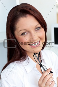 Confident businesswoman holding glasses 