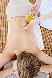 Beautiful woman having a massage with massage oil in a spa