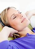 Relaxed woman listen to music lying on a sofa 
