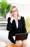 Ambitious businessowman talking on phone using her laptop 