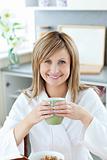 Charming woman drinking coffee in kitchen