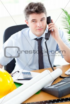 Attractive businessman in front of his desk