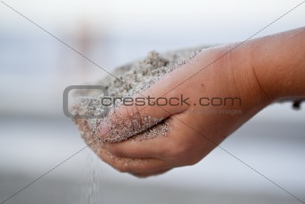 Child holding sand in the hands