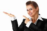 smiling modern business woman pointing finger on empty hand