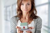Woman holding euros bills and house model 