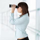 Business woman looking through binocular 