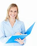 Charming businesswoman holding a folder smiling at camera 