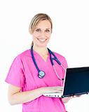 Delighted female nurse holding a laptop smiling at the camera 