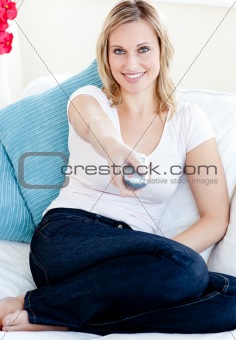 Good-looking woman watching TV on sofa