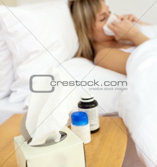 Ill woman lying in bed at home