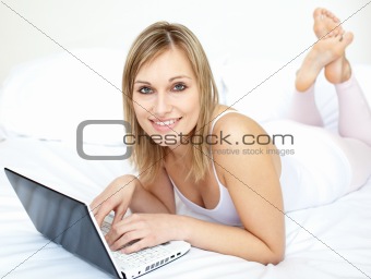 Attractive woman lying with a laptop on sofa