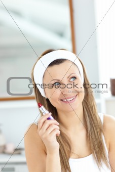 Positive woman holding a lipstick wearing a headband