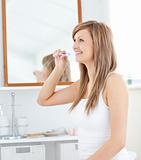 Blond young woman brush her teeth 