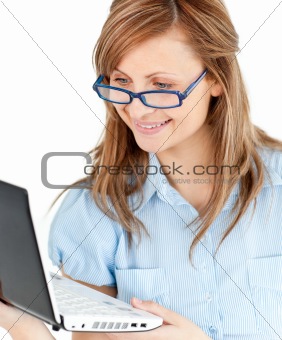 Ambitious businesswoman standing using her laptop 