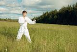 Man in kimono trains karate in open air